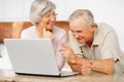 Portrait of a senior man and woman using a computer laptop at home